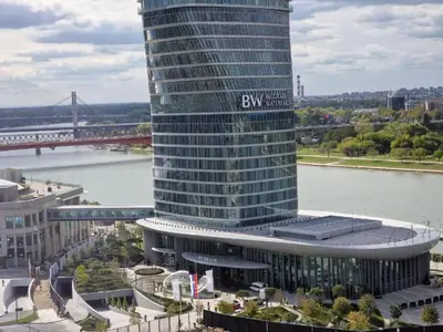 a large building with a sign on it next to a river at GIGI Apartment in Belgrade