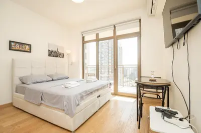 a bedroom with a bed and a television and a table at Belgrade Waterfront Nimax in Sajmište