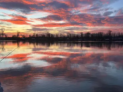 a sunset over a body of water with a cloudy sky at Splav na reci Savi in Ostružnica
