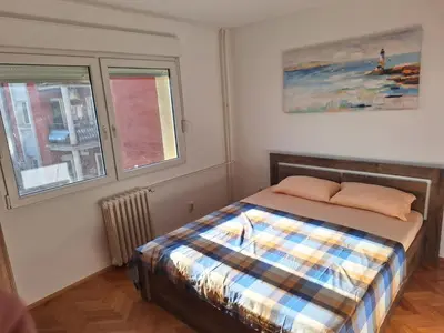 a bedroom with a bed and two windows at Temple saint sava in Dušanovac (historical)