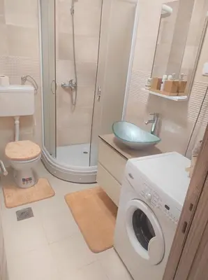 a bathroom with a washing machine and a shower at Bella Lux Centar in Mladenovac