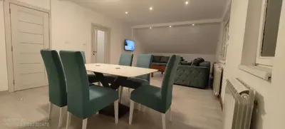a dining room with a table and green chairs at Privatna soba Marijana-Olja in Surčin