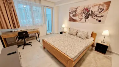 a bedroom with a bed and a desk in it at Apartman Laki in Tošin Bunar