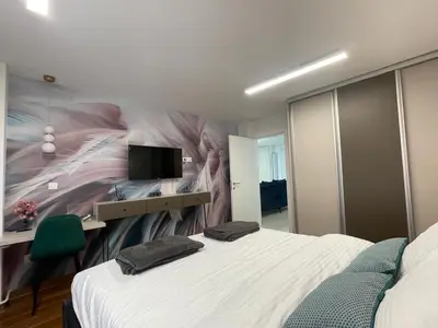a bedroom with a bed and a wall with a mural at NBG113 apartment in Belgrade