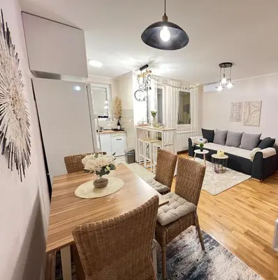 a living room with a table and chairs and a couch at Aero Fly apartment Belgrade in Belgrade