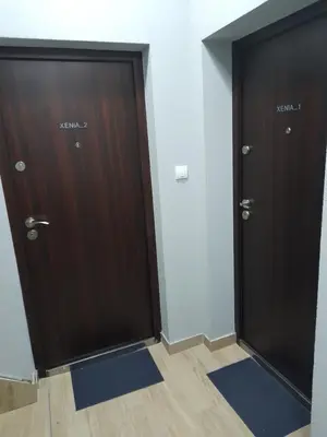 two brown doors in a room with blue mats at XENIA2 in Belgrade