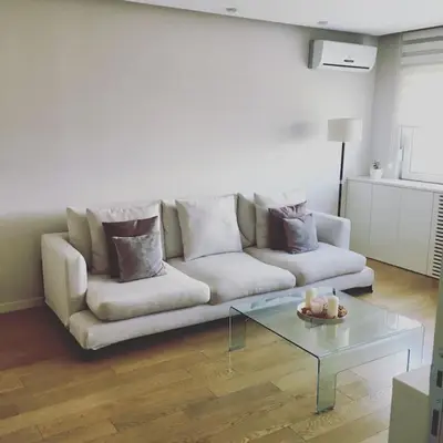 a living room with a white couch and a glass table at Maya's Downtown Apartment in Belgrade