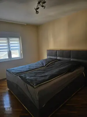 a large bed in a bedroom with a ceiling at Apartman Cvijetinovic in Ruma