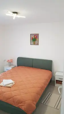 a bedroom with a bed with an orange blanket at BigNest in Smederevo