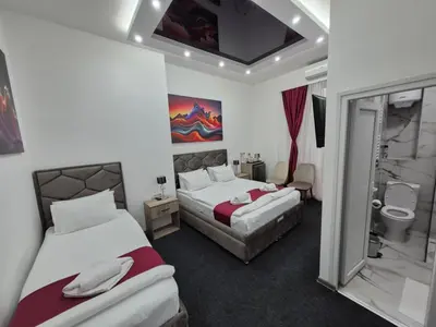 a hotel room with two beds and a bathroom at Authentic Belgrade Centre - 4 Suites in One Space, with patios in courtyard for smokers in Belgrade