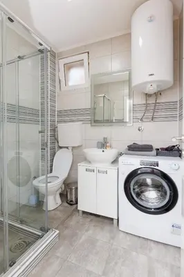 a bathroom with a toilet and a washing machine at Shiny in Bele Vode