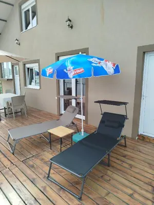 a blue umbrella and two chairs under a table at Splav na dan AXA in Barič