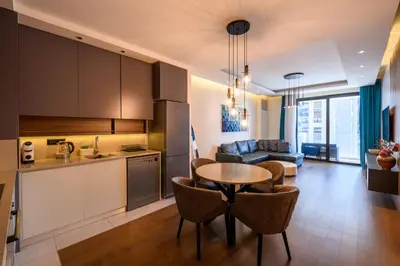 a kitchen and living room with a table and chairs at Luxury apartment with Pool&Gym in Belgrade