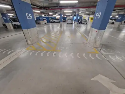 a parking garage with a parking lot with cars parked at Aqua Royal BW studio in Sajmište