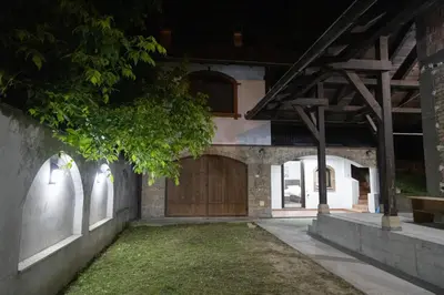 a house with a wooden garage door at night at Apartman Centar 18 in Ub