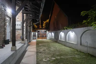 an alley at night with a brick wall at Apartman Centar 18 in Ub