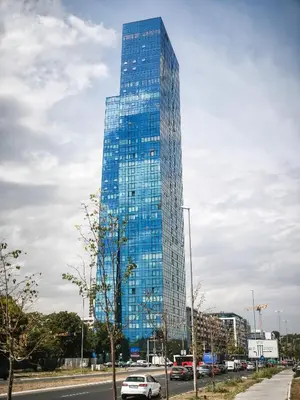 a tall glass building with cars parked in front of it at West Kula 14 in Belgrade
