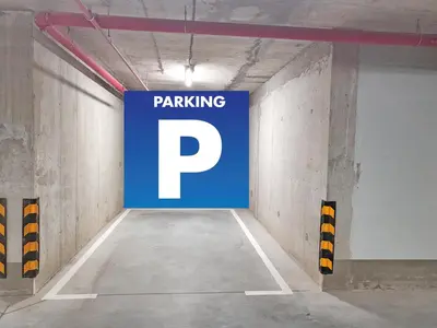 a parking garage with a parking sign on the wall at Panoramic View Lux Apartment BW in Sajmište