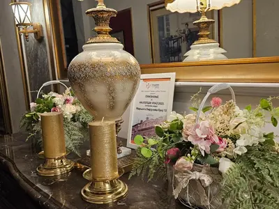 a table with a large vase and flowers on it at VANSVEL Boutique Apartment 14 in Belgrade