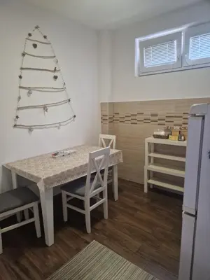a kitchen with a table and a christmas tree on the wall at Centro apartman 2 in Pančevo