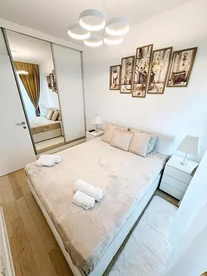 a white bedroom with a large bed with mirrors at SARA Lux A Blok in Belgrade