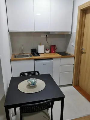 a small kitchen with a table with a bowl on it at Apartman Good Night in Surčin