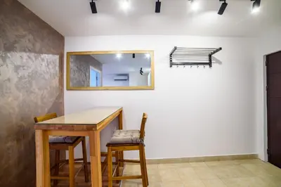 a dining room with a table and chairs and a mirror at Apartmani Sloboda in Belgrade