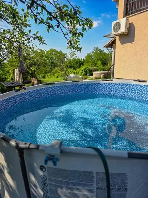 a swimming pool with blue water in front of a building at Vila Nera in Železnička Stanica Karlovački Vinogradi