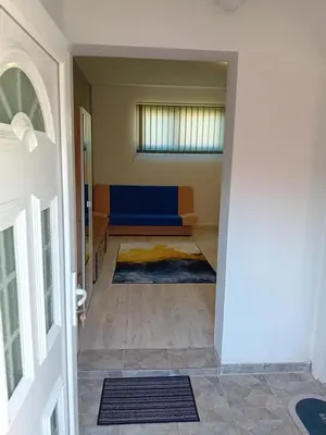 a hallway with a blue couch in a room at AlejaPark Inđija in Železnicka Stanica Inđija Selo