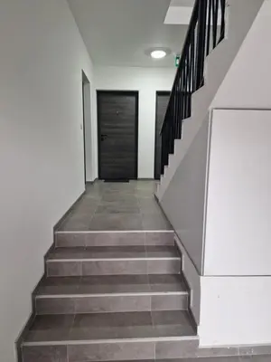 a hallway with stairs and a black door at Lux apartman 2 Ledine in Ledine