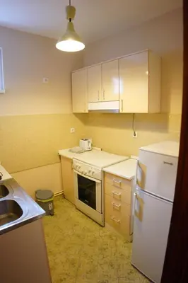 a kitchen with a white refrigerator and a sink at Apartmani Kula in Novi Banovci