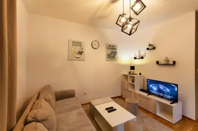 a living room with a couch and a tv at Apartment SIX - free parking in Belgrade