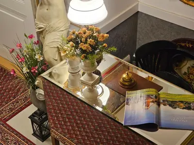 a table with flowers in vases and a book at Belgrade Luxury Suite 17 in Belgrade