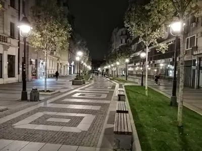 a city street at night with benches and lights at Belgrade Luxury Suite 19 in Belgrade