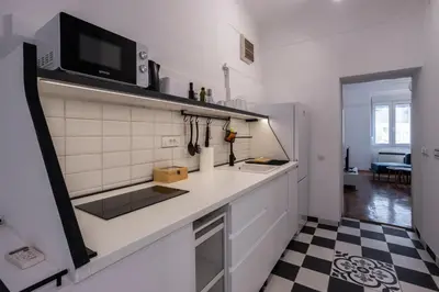 a kitchen with a white counter and a black and white floor at Black & White Delight in Belgrade