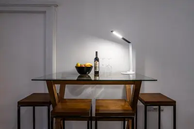 a table with a bottle of wine and a bowl of fruit at Elegant, Chique & Spacious Boho Loft in Belgrade