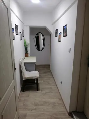 a hallway with a table and a chair and a mirror at Small low cost studio Dorcol in Belgrade