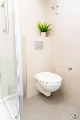 a bathroom with a toilet and a plant on a shelf at Center 2BDR additional living Room King bed 4 pers in Belgrade