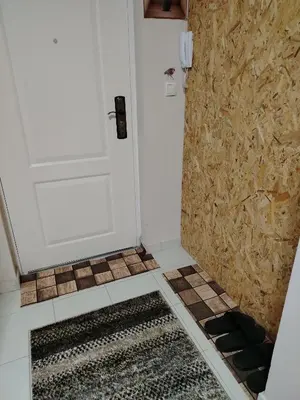 a bathroom with a white door and a tile floor at Apartman PRAMAC in Belgrade