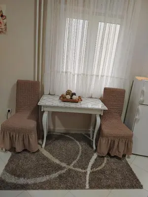 a table and two chairs in a kitchen with a window at Apartman PRAMAC in Belgrade