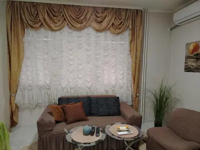 a living room with a couch and a large window at PRAMAC - stan na dan in Belgrade