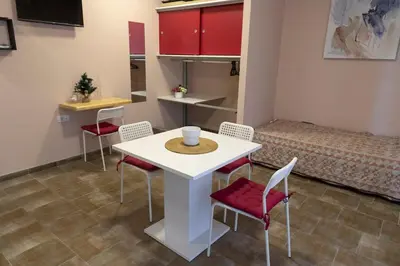 a room with a table and chairs and a bed at Studio Anrora 1 in Belgrade