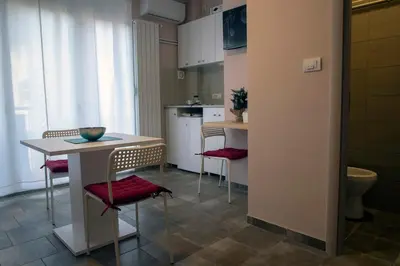 a kitchen with a table and chairs and a kitchen with a sink at Studio Anrora 4 in Belgrade
