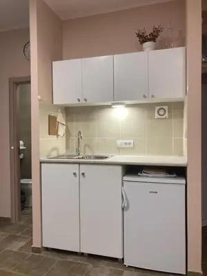 a kitchen with white cabinets and a sink at Studio Anrora 4 in Belgrade