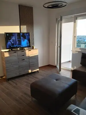 a living room with a flat screen tv on a dresser at Amare2 in Inđija