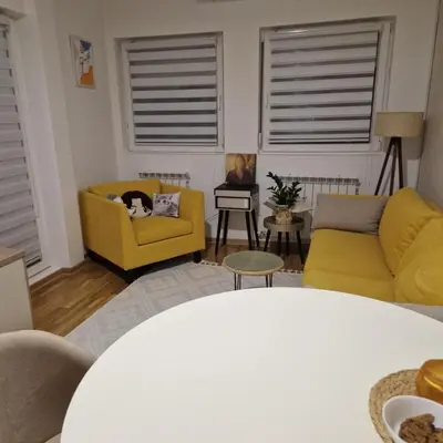 a living room with two chairs and a yellow couch at Stylish and cozy stay in Belgrade