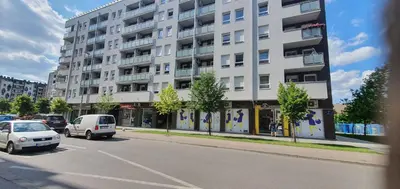 a large white building on a city street with cars at Apartman Fox in Belgrade