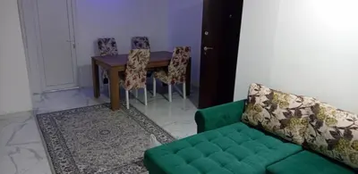 a living room with a green couch and a table at melvina 2 in Pančevo