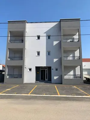 a white apartment building with a parking lot at Belgrade Airport Luxury Single in Surčin