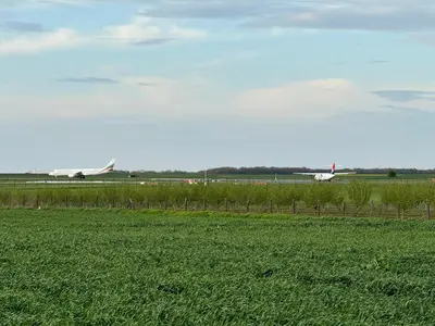 two planes on an airport runway with a green field at Belgrade Airport single bed in Surčin